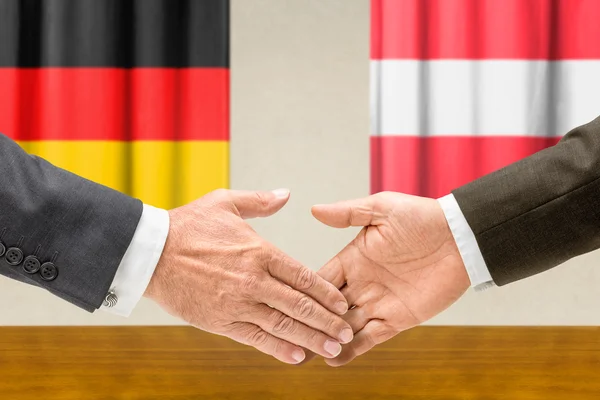 Представники Німеччини та Австрії потиснути один одному руки — стокове фото