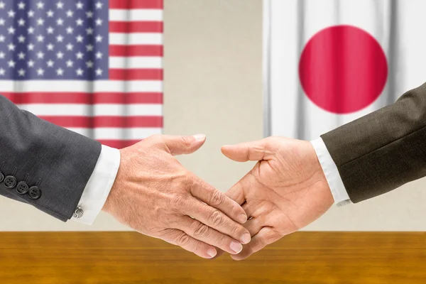 Representatives of the USA and Japan shake hands — Stock Photo, Image