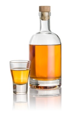 Bottle and shot glass filled with amber liquid clipart