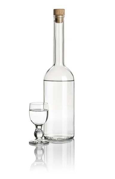 Liquor bottle and glass goblet filled with clear liquid — Stock Photo, Image