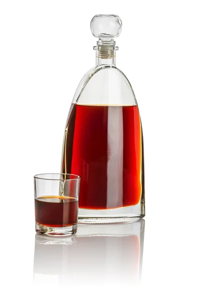 Carafe and drinking glass filled with brown liquid — Stock Photo, Image