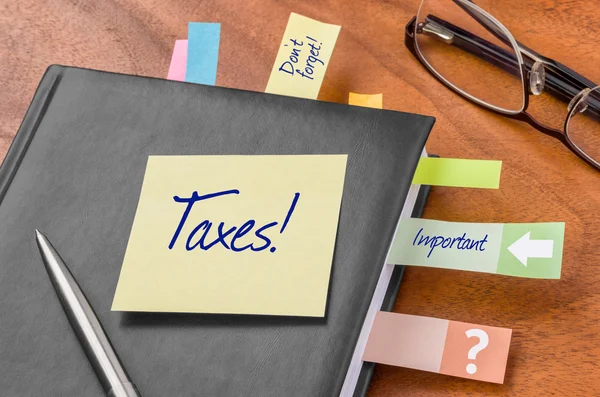 Planner with sticky note - Taxes — Stock Photo, Image