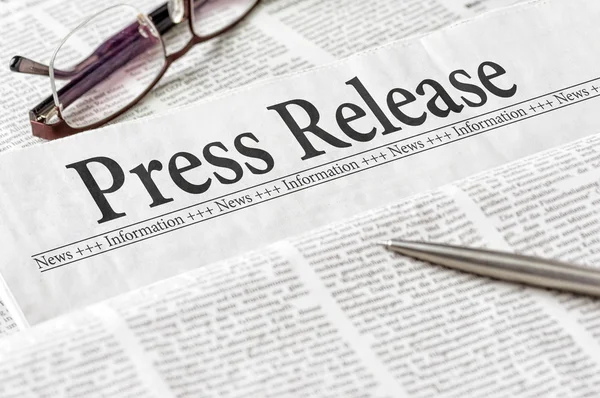 A newspaper with the headline Press Release — Stock Photo, Image