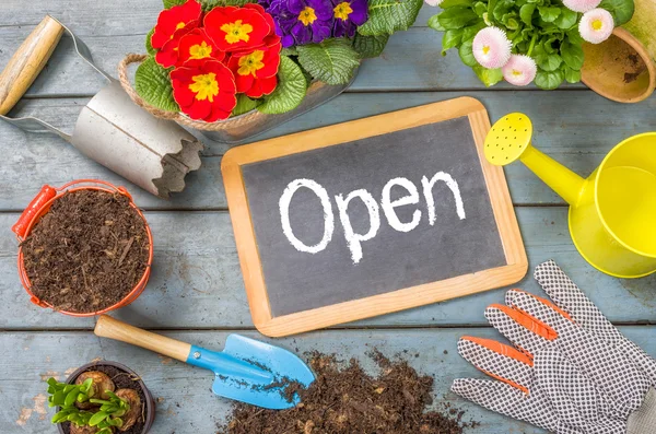 Pizarra sobre una mesa de plantas con herramientas de jardín - Abierto — Foto de Stock