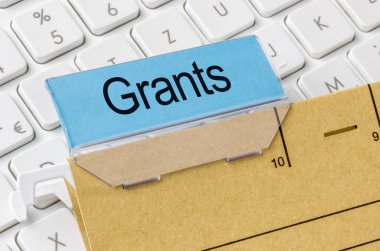 A brown file folder labeled with Grants clipart