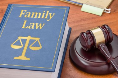 A law book with a gavel - Family law clipart