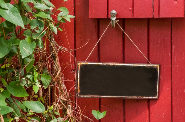 Panneau métallique vide devant un mur en bois rouge — Photo