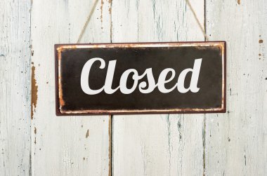 Old metal sign in front of a white wooden wall - Closed clipart