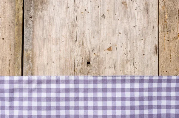 Toalha de mesa quadriculada violeta em um fundo de madeira rústico — Fotografia de Stock