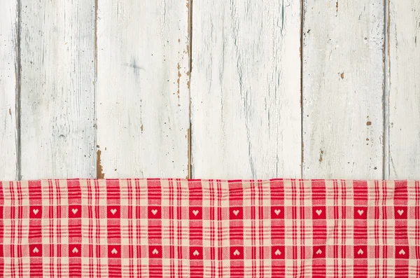 Red checkered tablecloth with hearts on a white wooden backgroun — Stock Photo, Image