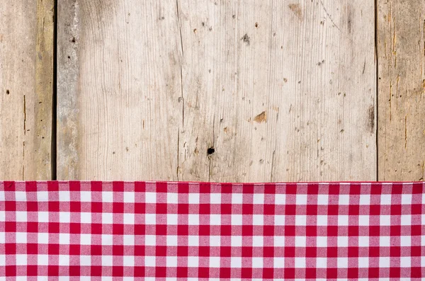 Toalha de mesa quadriculada vermelha em um fundo de madeira rústico — Fotografia de Stock