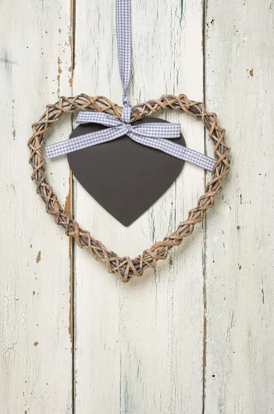 Geflochtesnes Herz mit Tafel vor weißen Holzbrettern — 스톡 사진