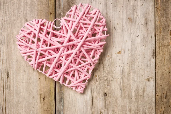 Розовое сердце на деревенском деревянном фоне — стоковое фото