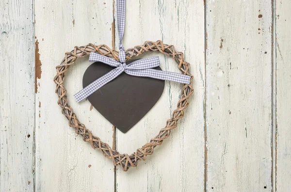 Braided heart with a sign on a white wooden background — Stock Photo, Image