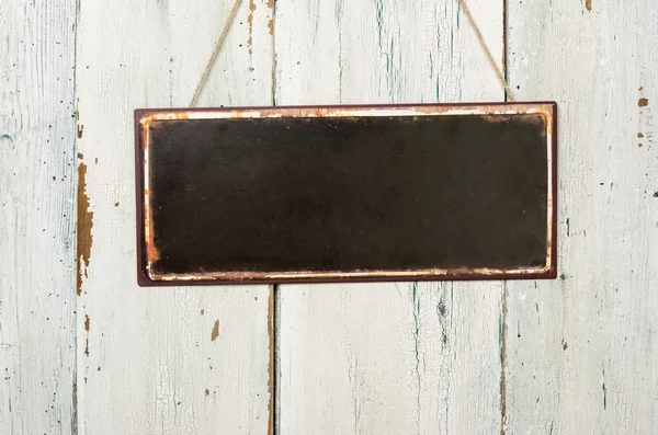 Leeres Metallschild vor einer weißen Holzwand — Stockfoto