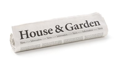 Rolled newspaper with the headline House and Garden clipart