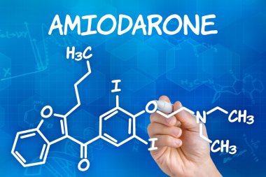 Hand with pen drawing the chemical formula of Amiodarone clipart