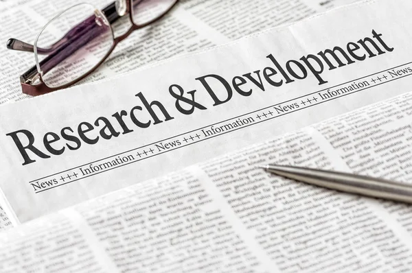 En tidning med rubriken forskning och utveckling — Stockfoto