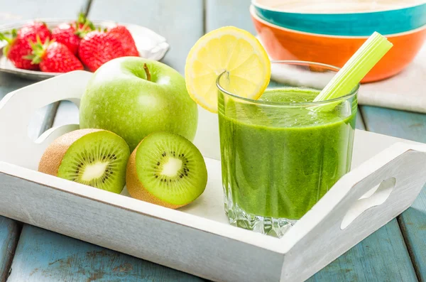 Frullato verde su un vassoio con frutta fresca — Foto Stock