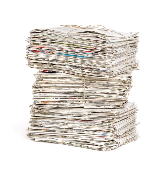 Paquetes de periódicos apilados sobre un fondo blanco — Foto de Stock