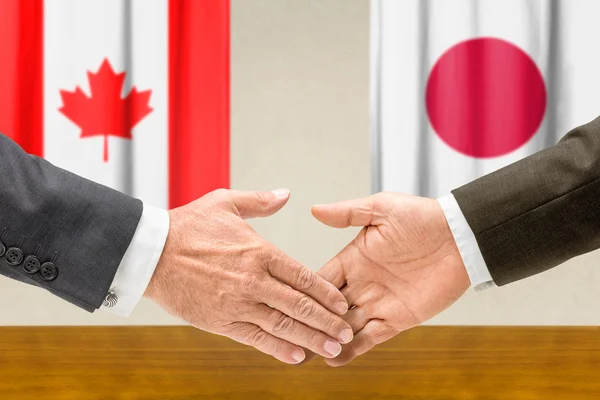 Representatives of Canada and Japan shake hands