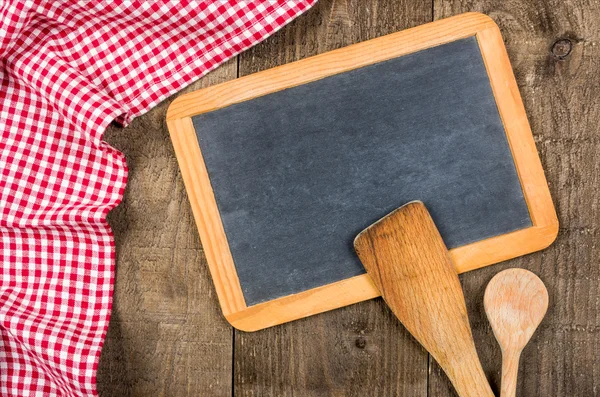 Pizarra y cucharas de madera con un paño a cuadros rojo — Foto de Stock