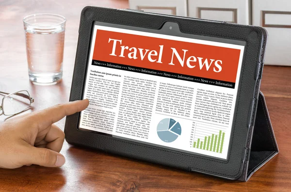 Een tablet pc op een bureau - Travel News — Stockfoto