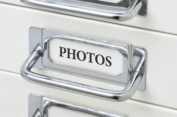 Un armario de cajones con la etiqueta Fotos — Foto de Stock