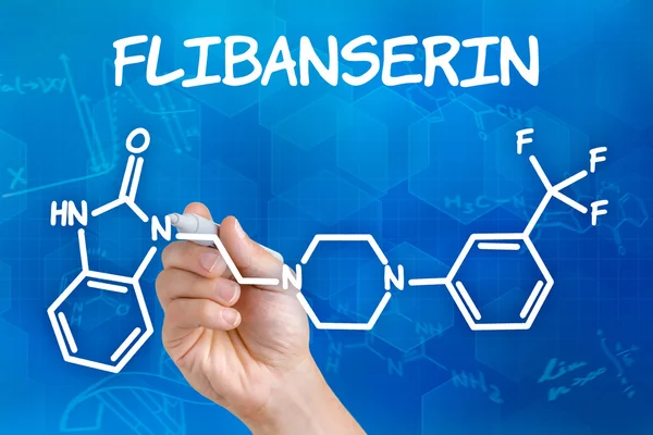 Hand with pen drawing the chemical formula of Flibanserin — Stock Photo, Image