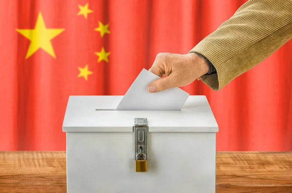 Uomo che mette una scheda elettorale in una casella di voto - Cina — Foto Stock