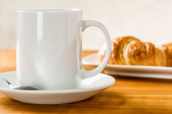 Een koffiemok met croissants — Stockfoto