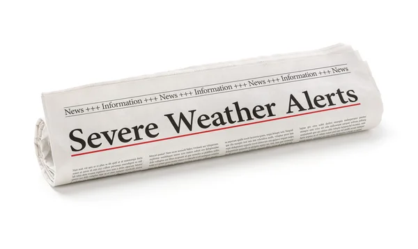 Rolled newspaper with the headline Severe Weather Alerts — Stock Photo, Image