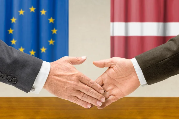 Vertegenwoordigers van de Eu en Letland schudden handen — Stockfoto