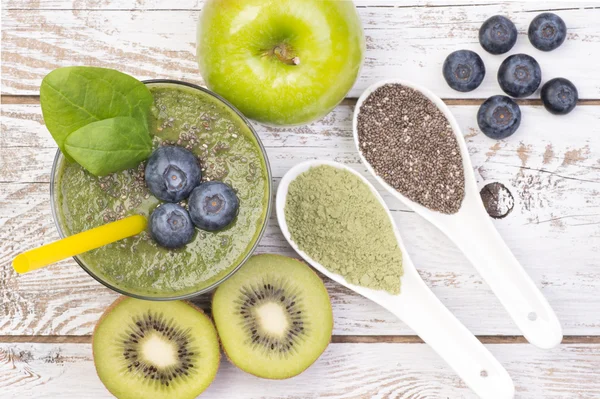 Green smoothie  on white, wooden background, top view — Stock Photo, Image