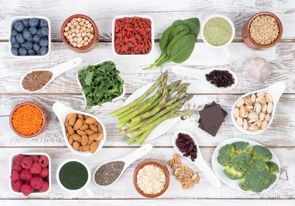 Hälsosam mat kallas super livsmedel på vit, trä bakgrund, ovanifrån — Stockfoto