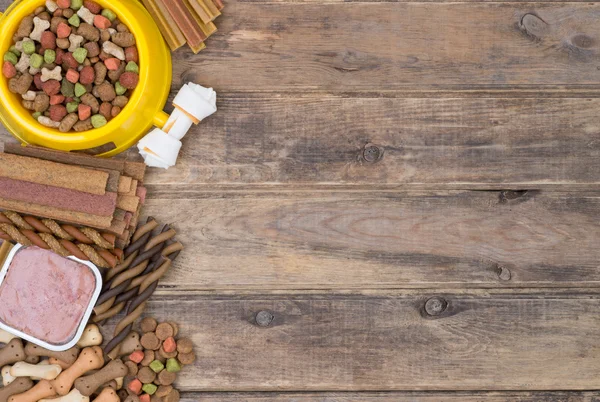 Selezione di cibo per cani su sfondo in legno con spazio copia, vista dall'alto — Foto Stock