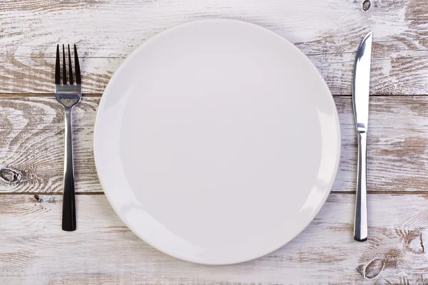 Empty plate on white wooden background — Stock Photo, Image