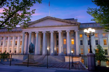 Washington DC - 18 Temmuz 2018; ABD Hazine Bakanlığı 'nın ön girişi arka planda gün batımı ve ön planda demir güvenlik çiti ile