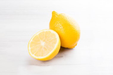 Beyaz ahşap arka planda izole edilmiş taze Sicilya limonu dilimi..