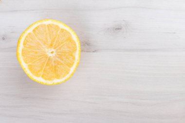 Beyaz ahşap arka planda izole edilmiş taze Sicilya limonu dilimi. Üst görünüm.