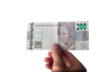 Elinde 200 reais banknot tutan adam beyaza izole edilmiş. Brezilya parası işte. Ödeme.