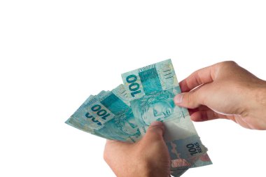 Elinde 100 reais banknot tutan adam beyaza izole edilmiş. Brezilya parası..