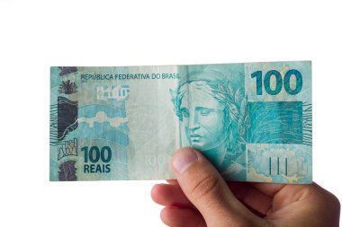 Elinde 100 reais banknot tutan adam beyaza izole edilmiş. Brezilya parası..