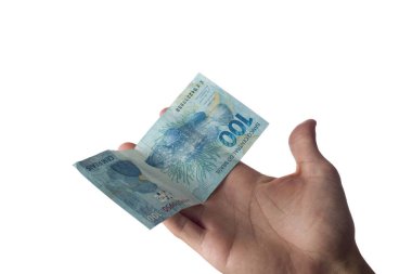 Elinde 100 reais banknot tutan adam beyaza izole edilmiş. Brezilya parası..