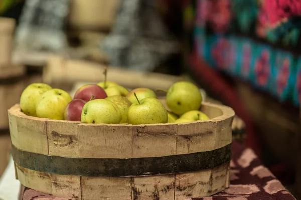 Manzanas verdes y rojas en un plato de madera —  Fotos de Stock