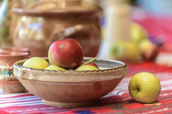 Яблоки и керамический шар на традиционной крышке стола — стоковое фото
