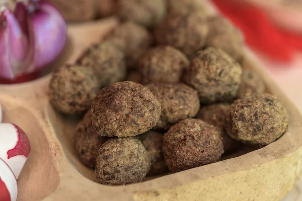 Aperitivos con albóndigas. rábanos y cebollas en plato de madera —  Fotos de Stock