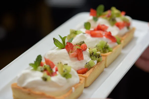 Tortas com chantilly e morangos e folhas de hortelã — Fotografia de Stock