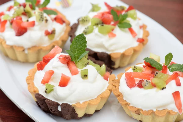 Tarts with whipped cream and strawberries and mint leaves — Stock Photo, Image