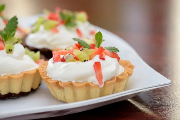 Tortas com chantilly e morangos e folhas de hortelã — Fotografia de Stock